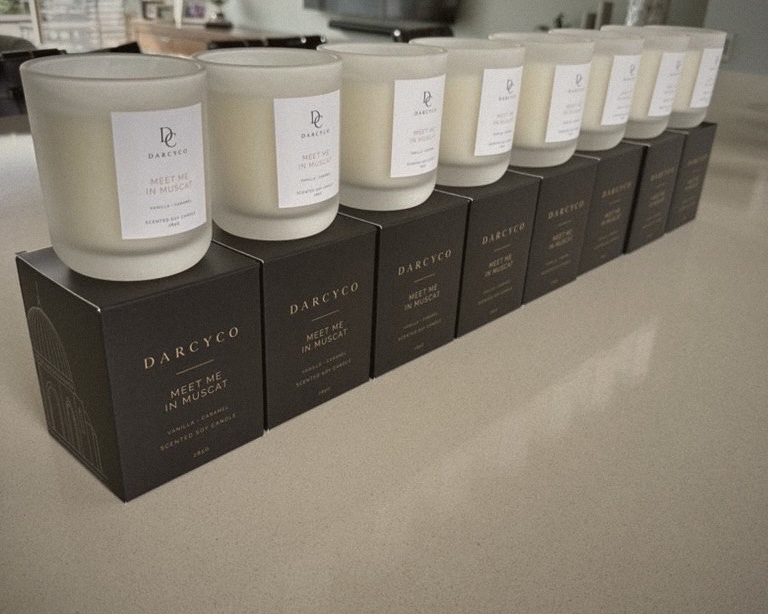 Meet Me in Muscat candles lined up on their black boxes