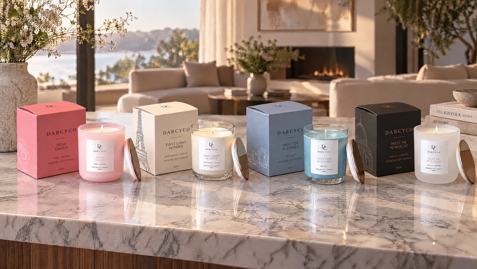 All four DARCYCO candles with their boxes on a marble bench